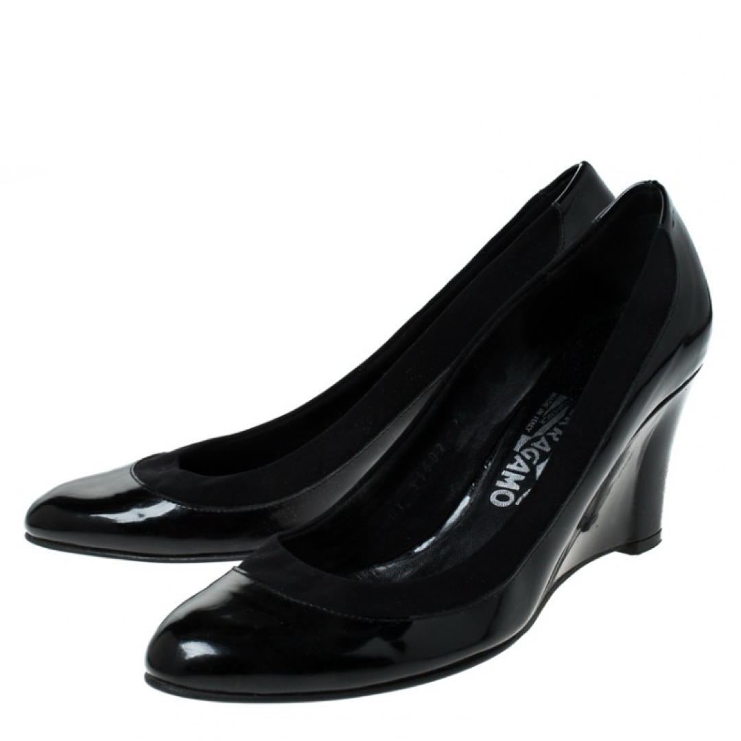 These black pumps from Salvatore Ferragamo are simple but a must-have. Crafted using patent leather, and balanced on wedges, the round-toe pumps are complete with the brand label on the insoles. They are high in both style and comfort.