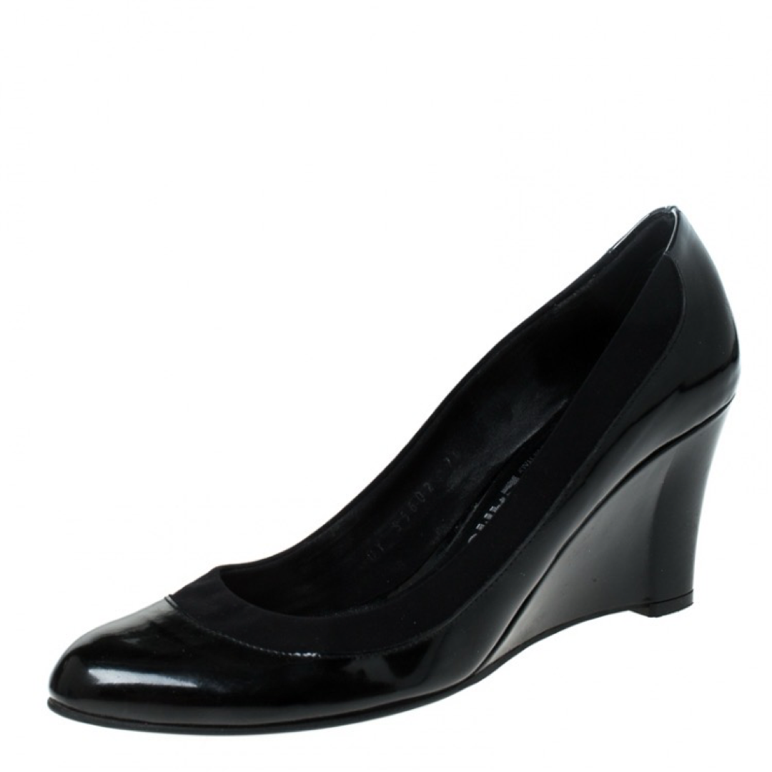 These black pumps from Salvatore Ferragamo are simple but a must-have. Crafted using patent leather, and balanced on wedges, the round-toe pumps are complete with the brand label on the insoles. They are high in both style and comfort.